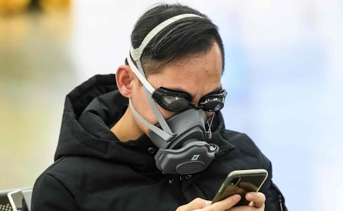 persona con mascherina e smartphone
